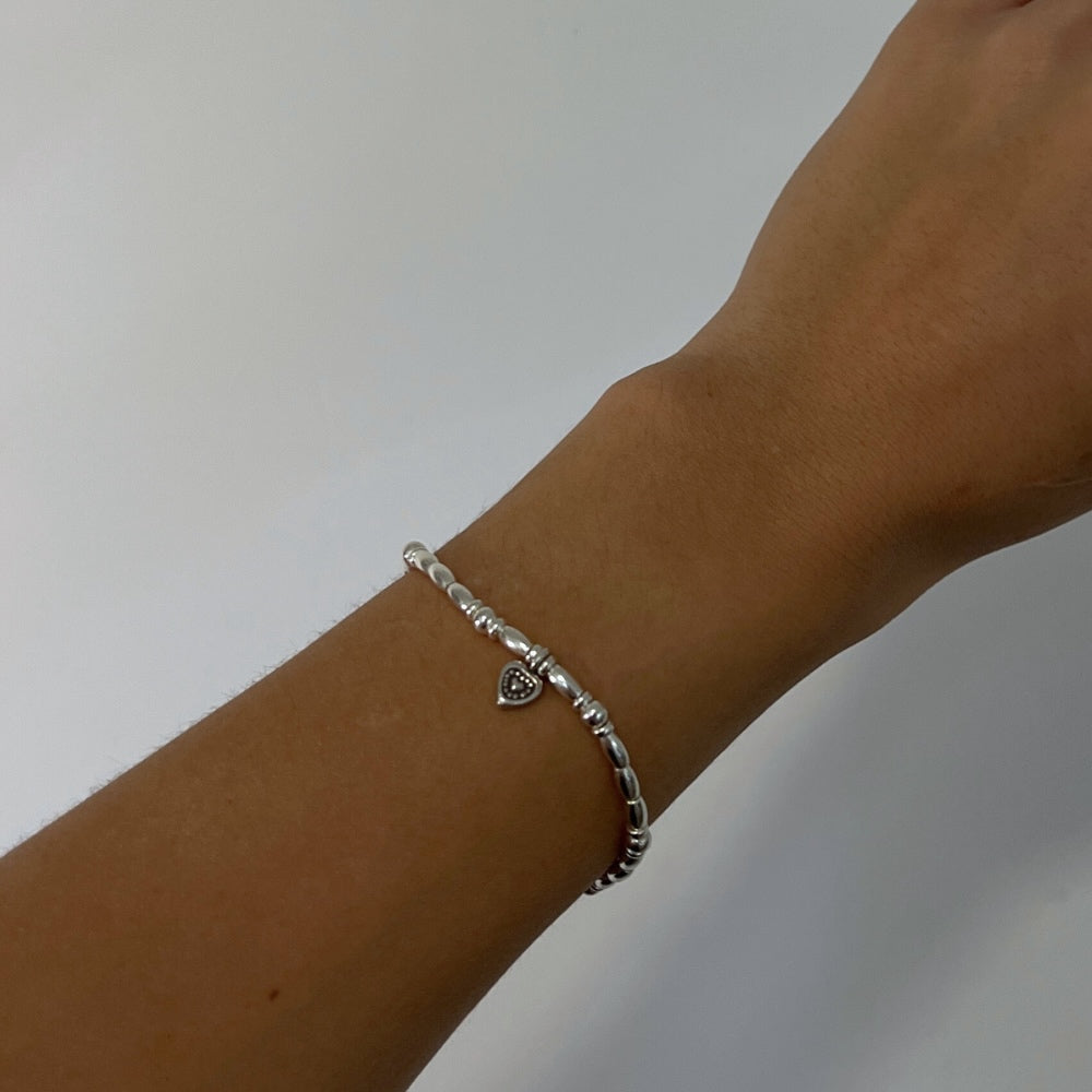 Indulge in the perfect expression of love with our Silver Sweetheart Charm Beaded Bracelet. Made with sterling silver beads, this bracelet is delicately strung on wax string, featuring a charming heart at its centre. Add a touch of elegance to any outfit and let your love shine through!