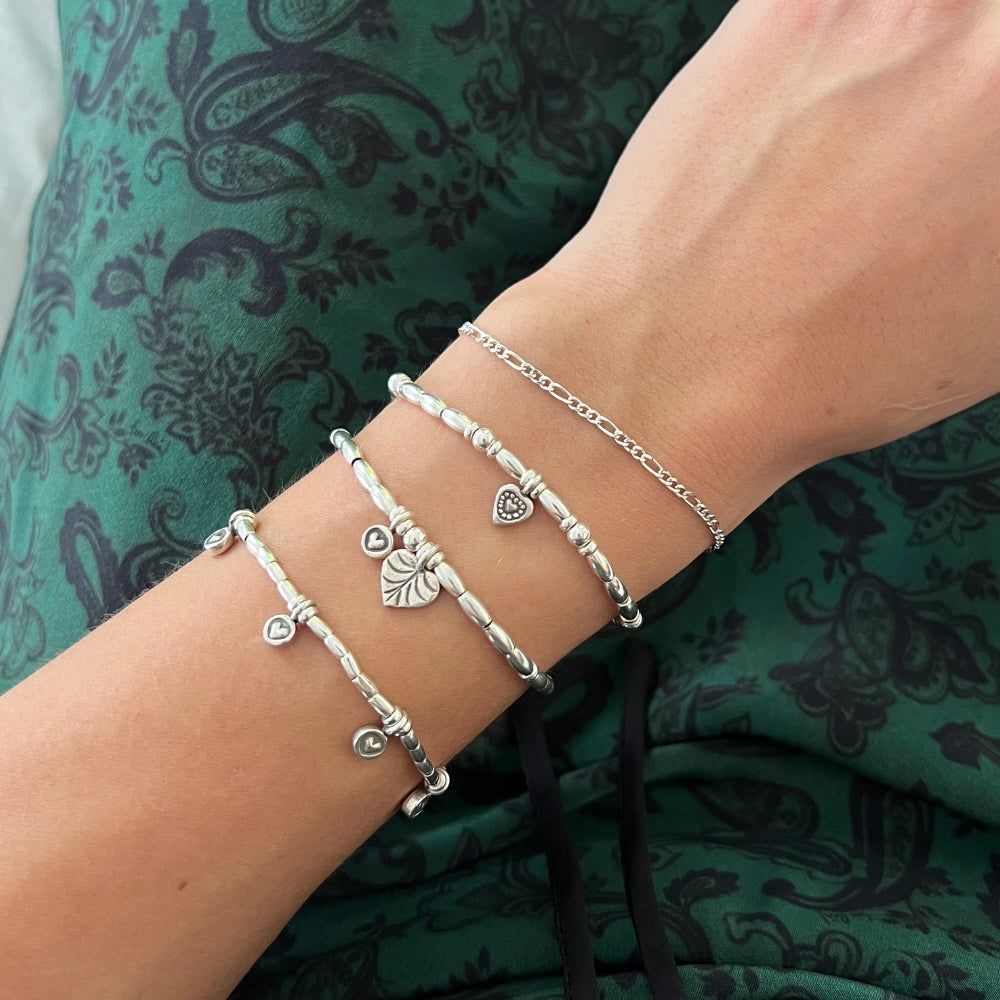 Join the Love Club with this adorable sterling silver beaded bracelet. Strung with delicate silver beads and two charming heart accents, this bracelet is sure to add a touch of love and style to any outfit. Whether you're feeling flirty or romantic, this bracelet has got you covered!