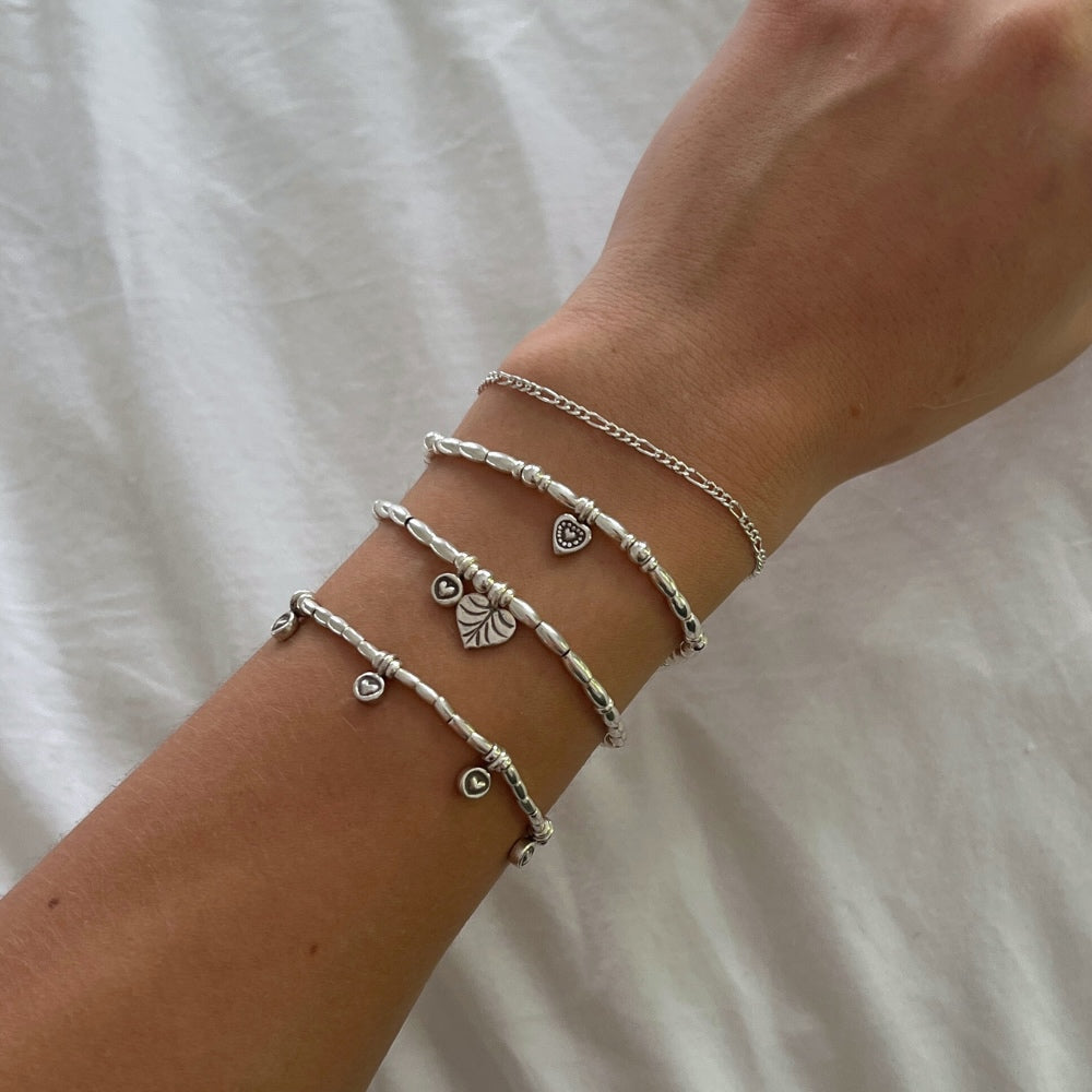 Join the Love Club with this adorable sterling silver beaded bracelet. Strung with delicate silver beads and two charming heart accents, this bracelet is sure to add a touch of love and style to any outfit. Whether you're feeling flirty or romantic, this bracelet has got you covered!