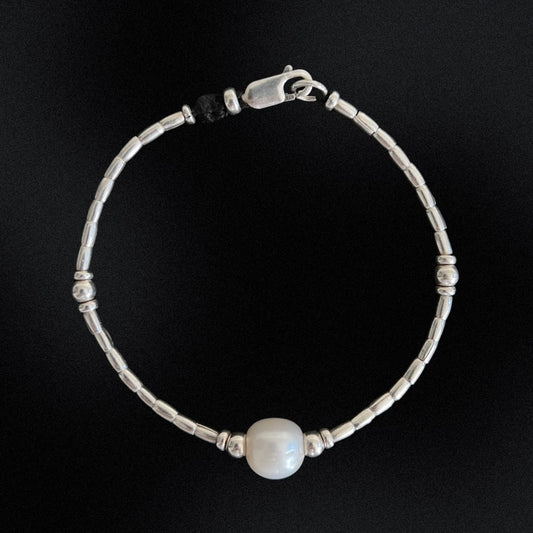 Introducing our Hill Tribe Silver & Pearl Bracelet, a fusion of tradition and elegance. Meticulously handcrafted in Australia, this bracelet features a central freshwater pearl embraced by intricate silver beads. The pearl, symbolising purity and timeless beauty, adds sophistication. Finished with a lobster clasp, this piece is versatile for any occasion, blending cultural heritage with refined style. Elevate your look with this timeless treasure.